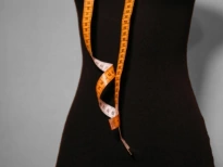 A mannequin with a measuring tape wrapped around it